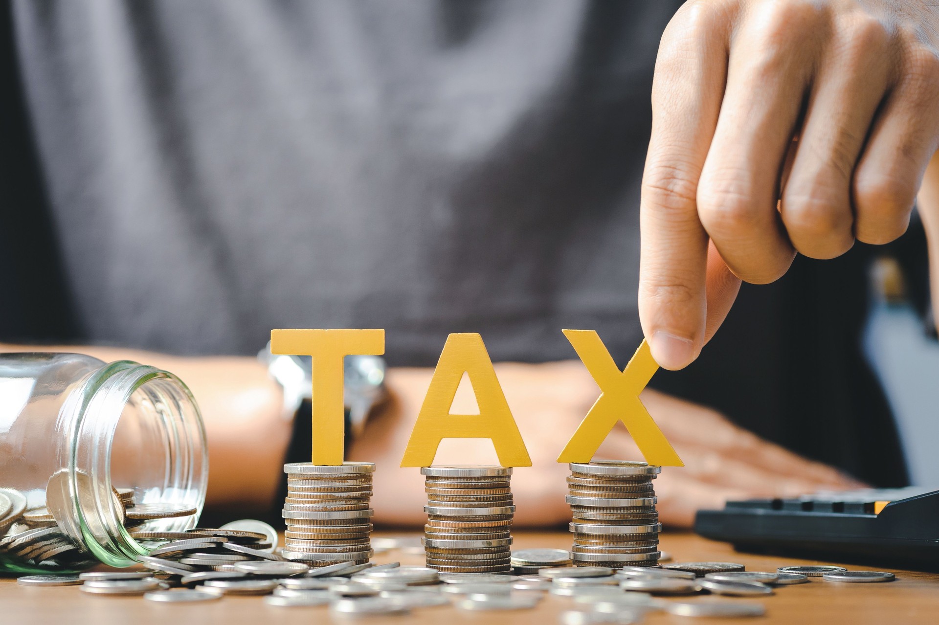 Tax Concept.Word tax and stacked coins put on desks
