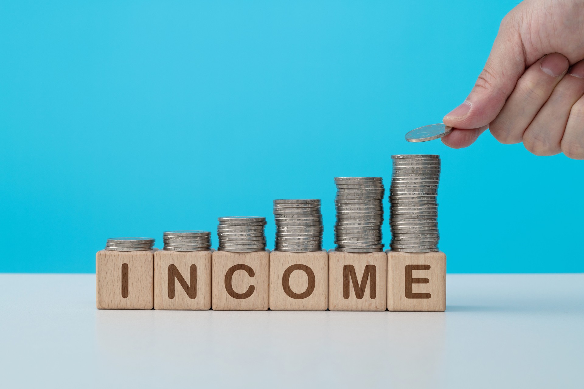 Stack of coins on word income